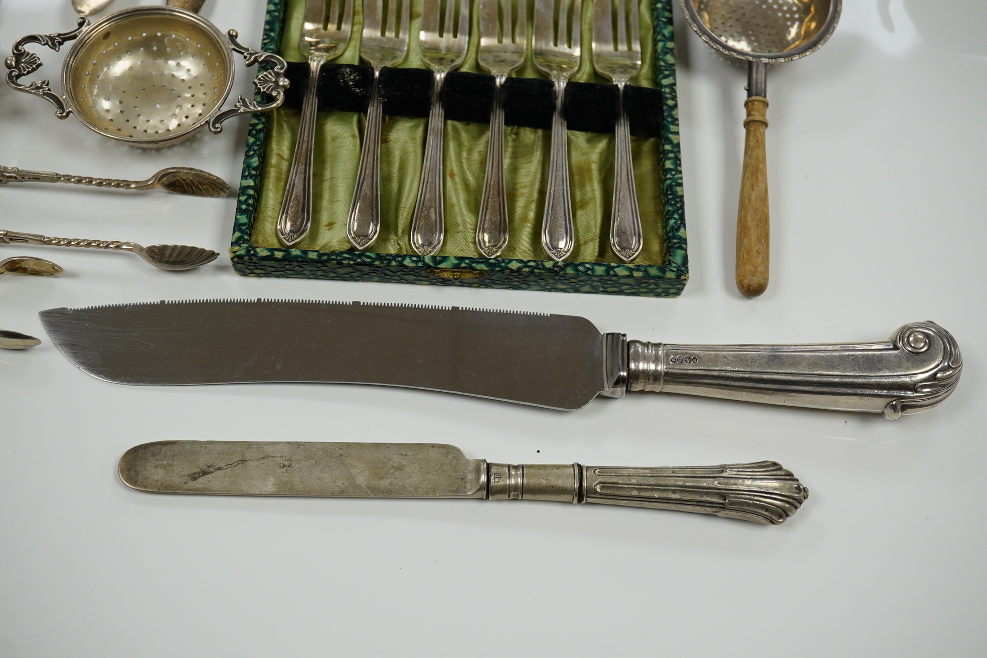 Sundry silver including cake forks, sifter ladle, salt spoons, Victorian silver handled bread knife, etc. Condition - poor to fair